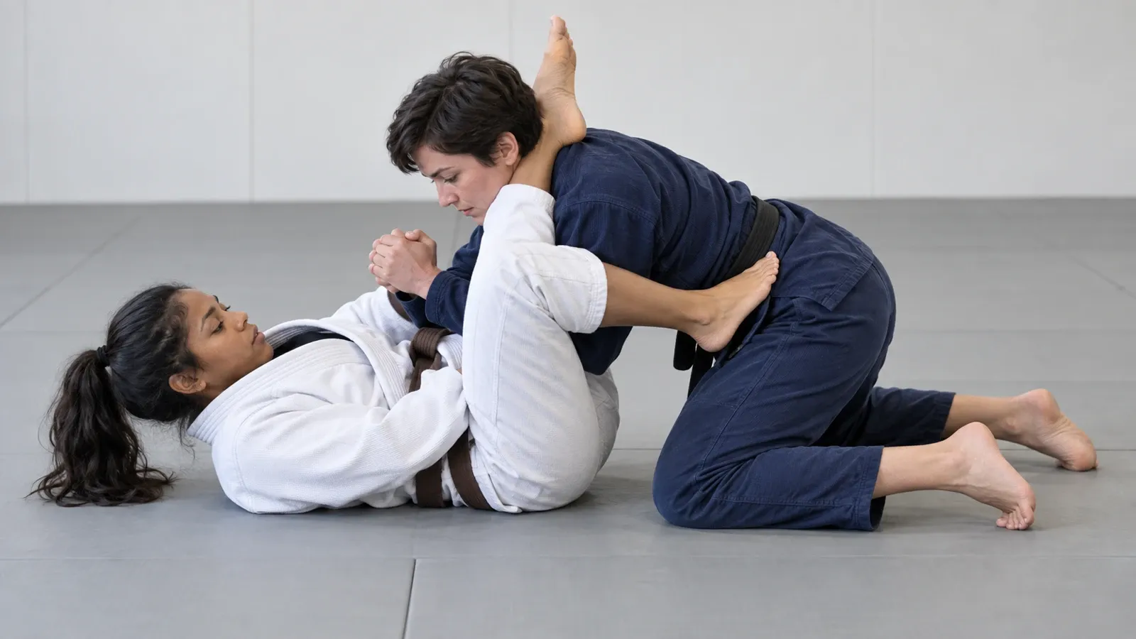A grappler defending an armbar by turning the thumb up and stacking their weight forward over the attacker’s hips.