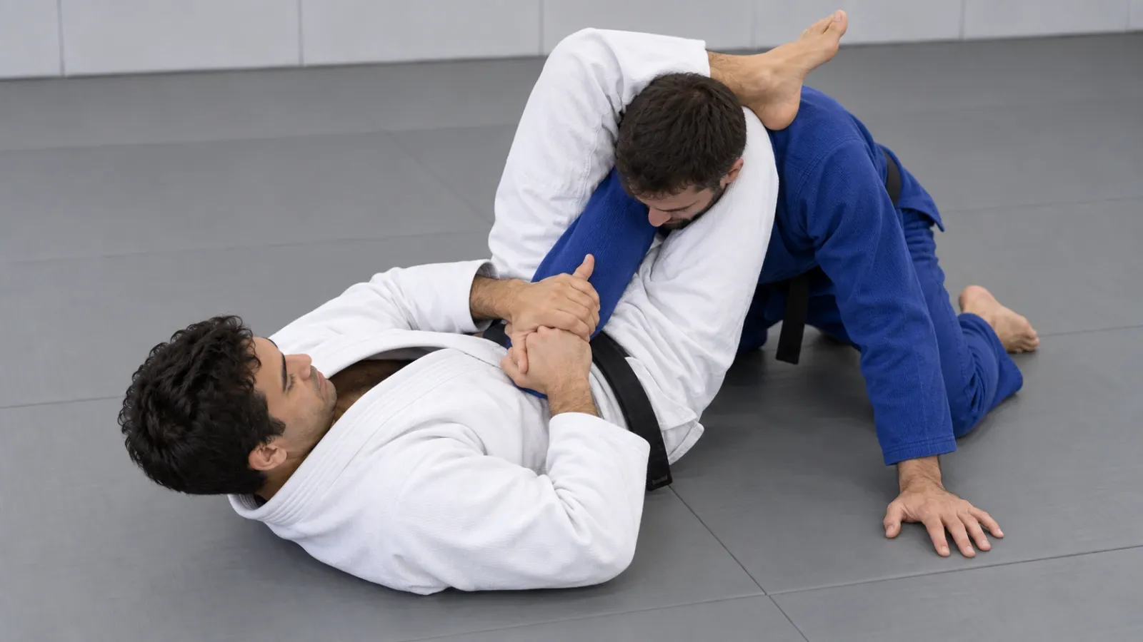The armbar position with the knees pinched together and the opponent’s wrist controlled, thumb pointing up.
