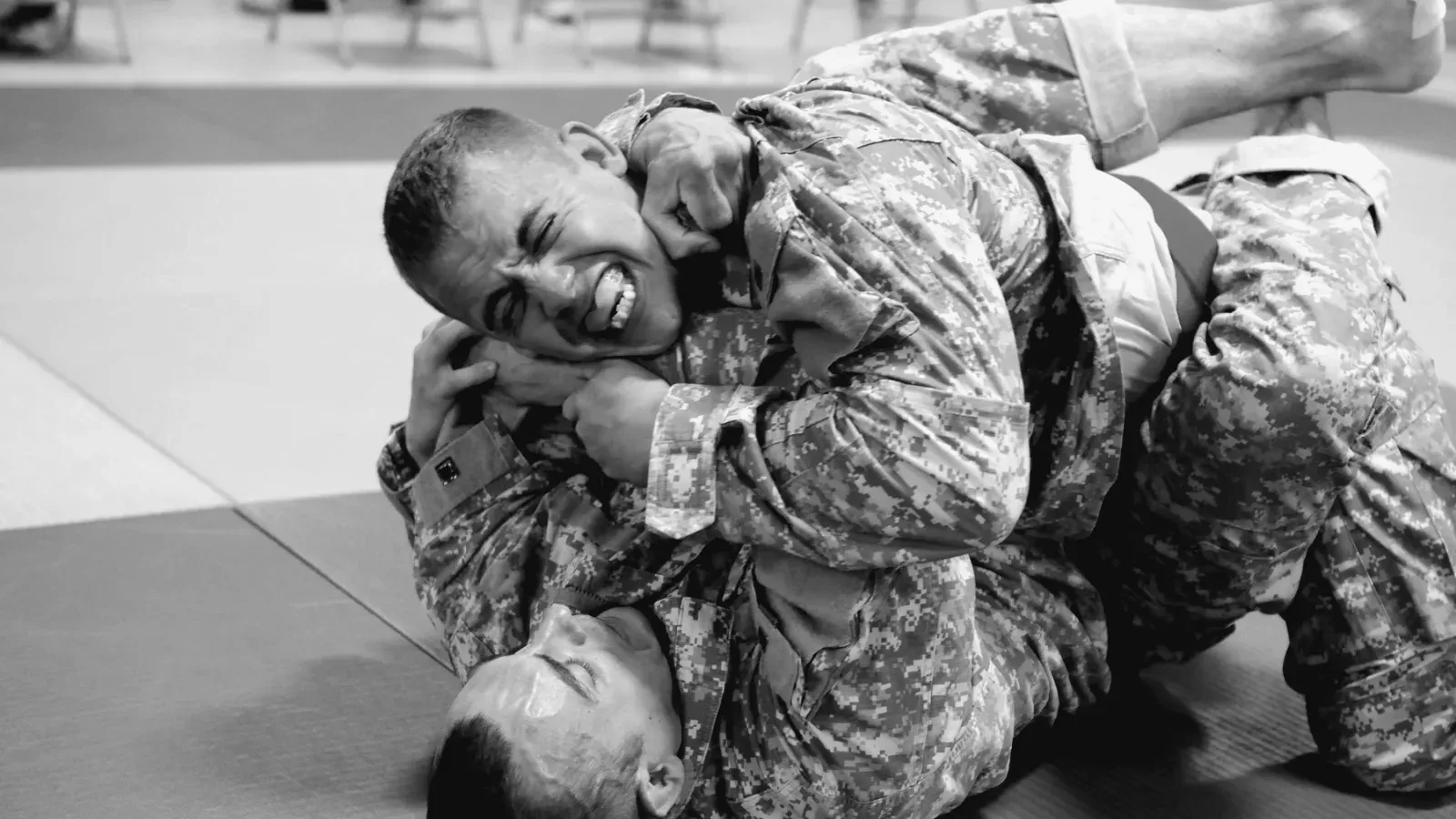 Brazilian Jiu Jitsu practitioners army combatives ezekiel choke while training on the mat.