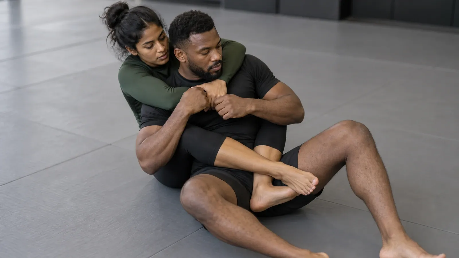 One grappler behind another with the legs crossed and locked in a triangle around the torso.