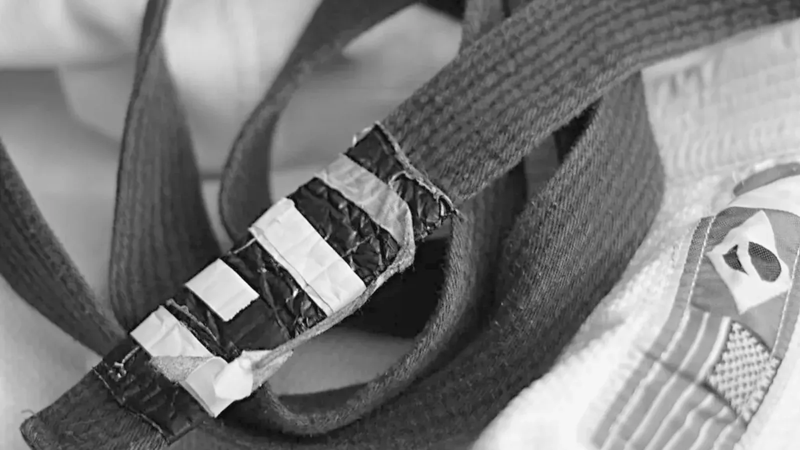 Brazilian Jiu Jitsu practitioners belt detail while training on the mat.