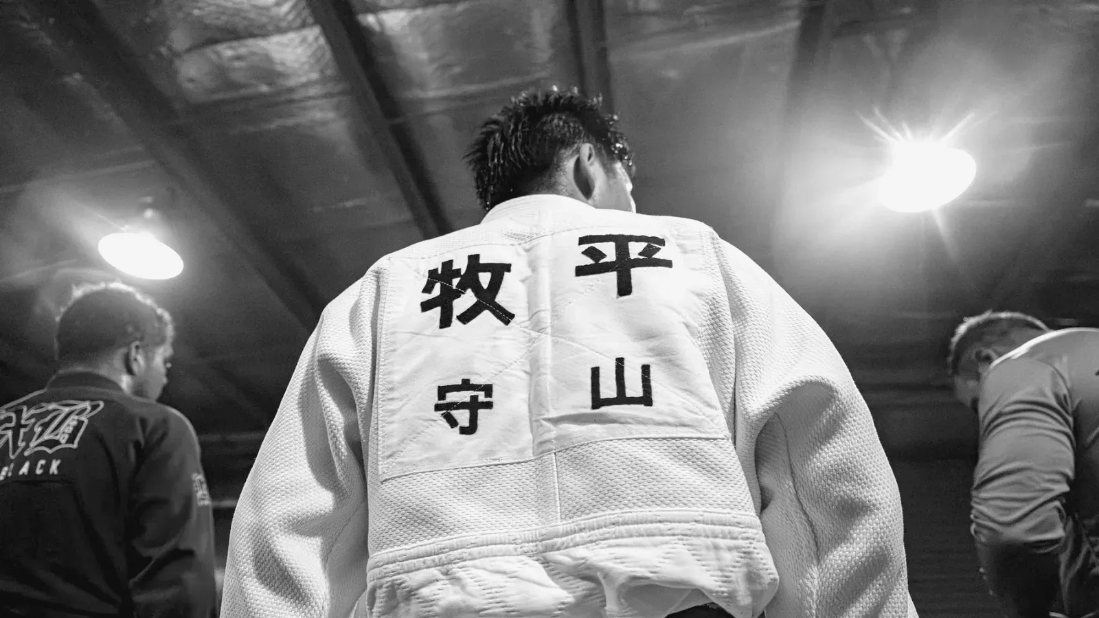 Brazilian Jiu Jitsu practitioners gi detail while training on the mat.