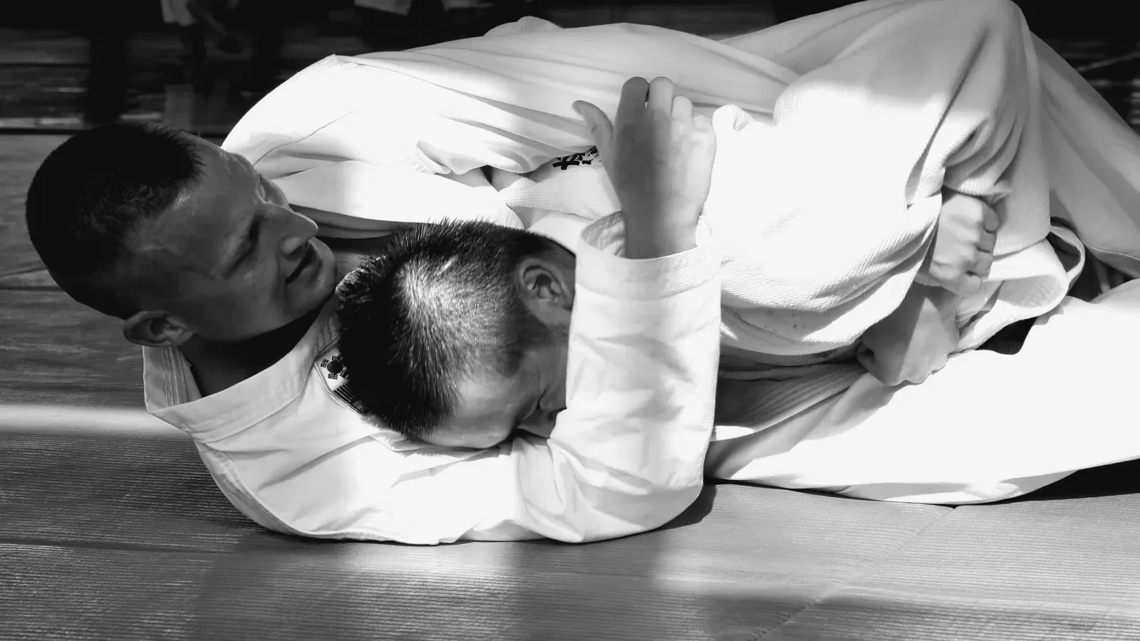 Brazilian Jiu Jitsu practitioners gi ground control while training on the mat.