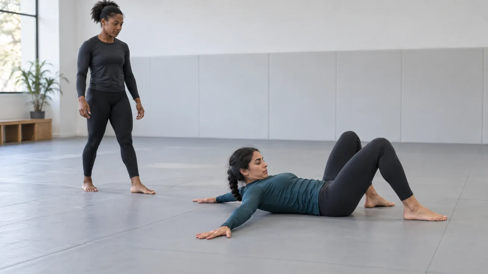 A grappler landing on the mat with the arm slapping out and the chin tucked.