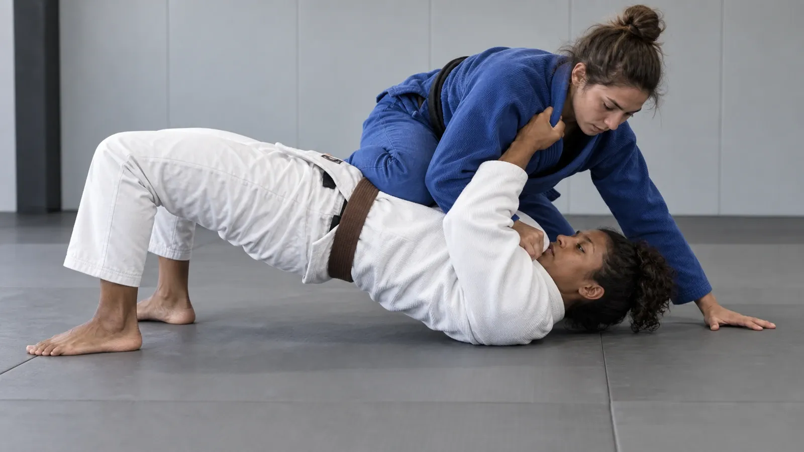 A grappler underneath side control driving their hips off the mat onto their shoulders.