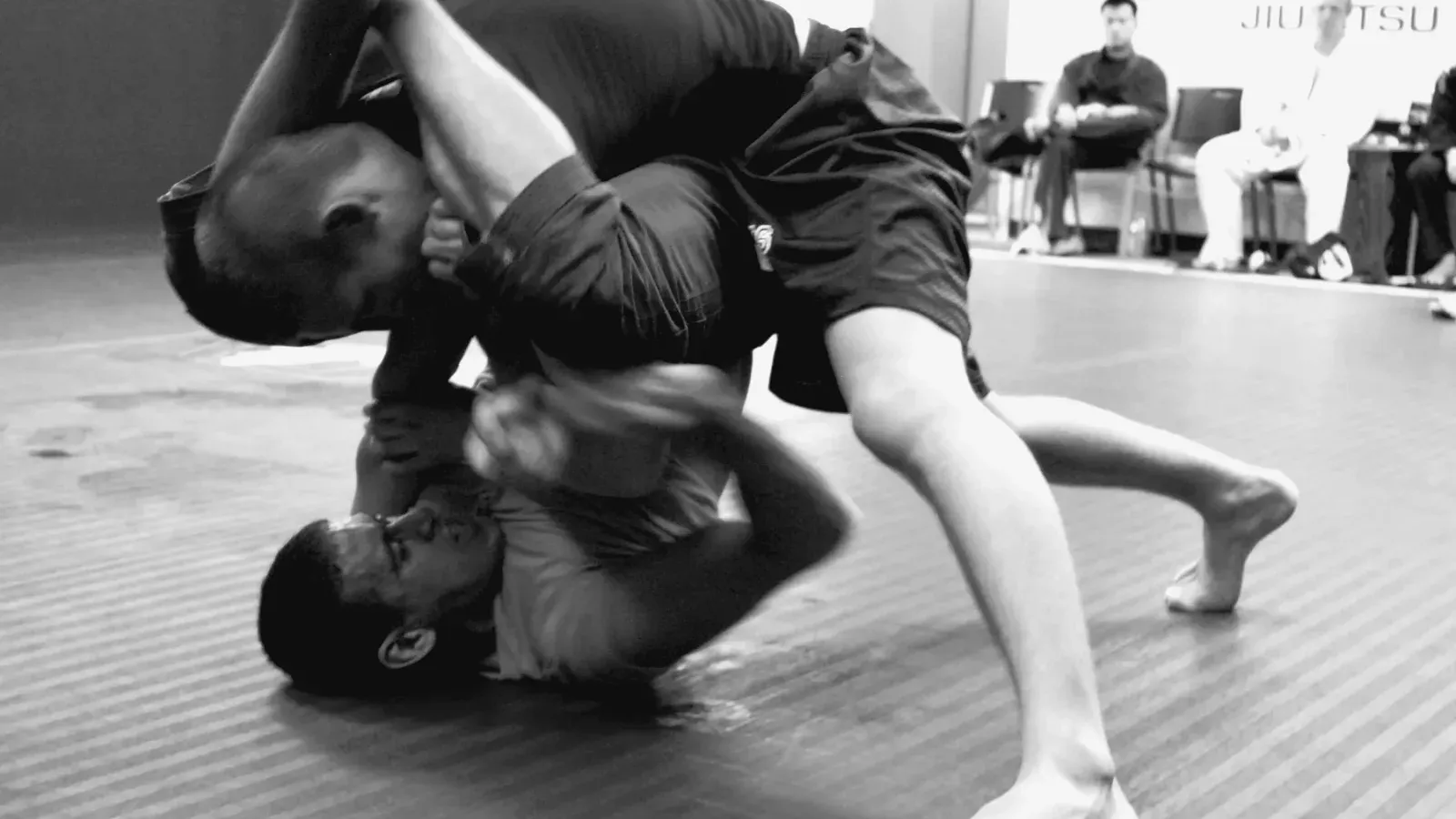 Brazilian Jiu Jitsu practitioners no gi action bw while training on the mat.