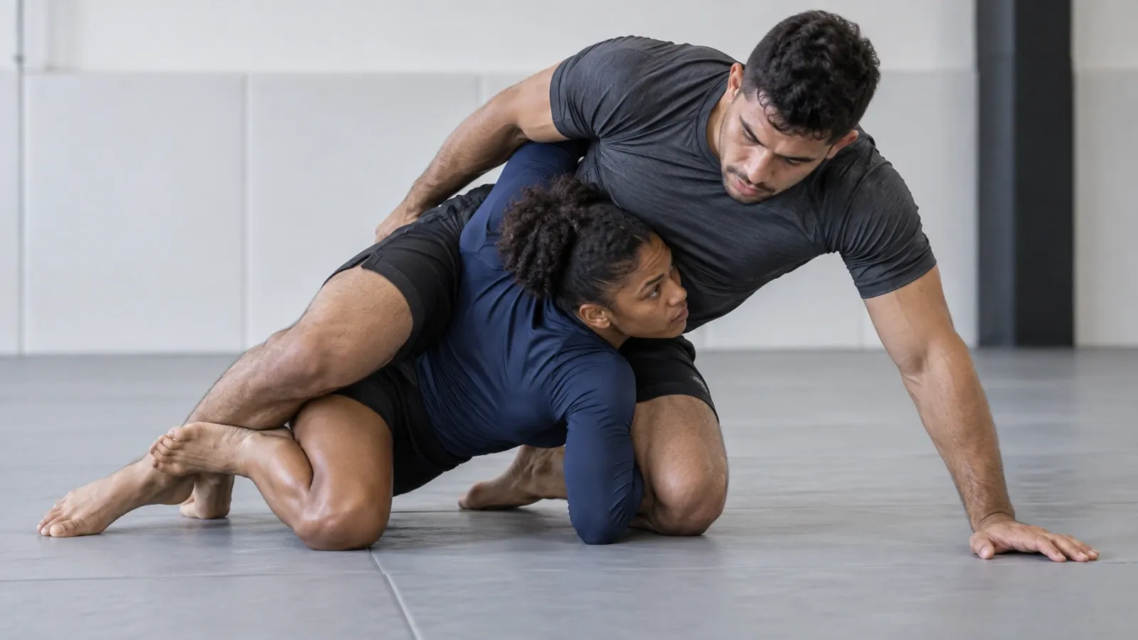 A bottom half guard player coming up onto their side with an underhook, driving into the dogfight.