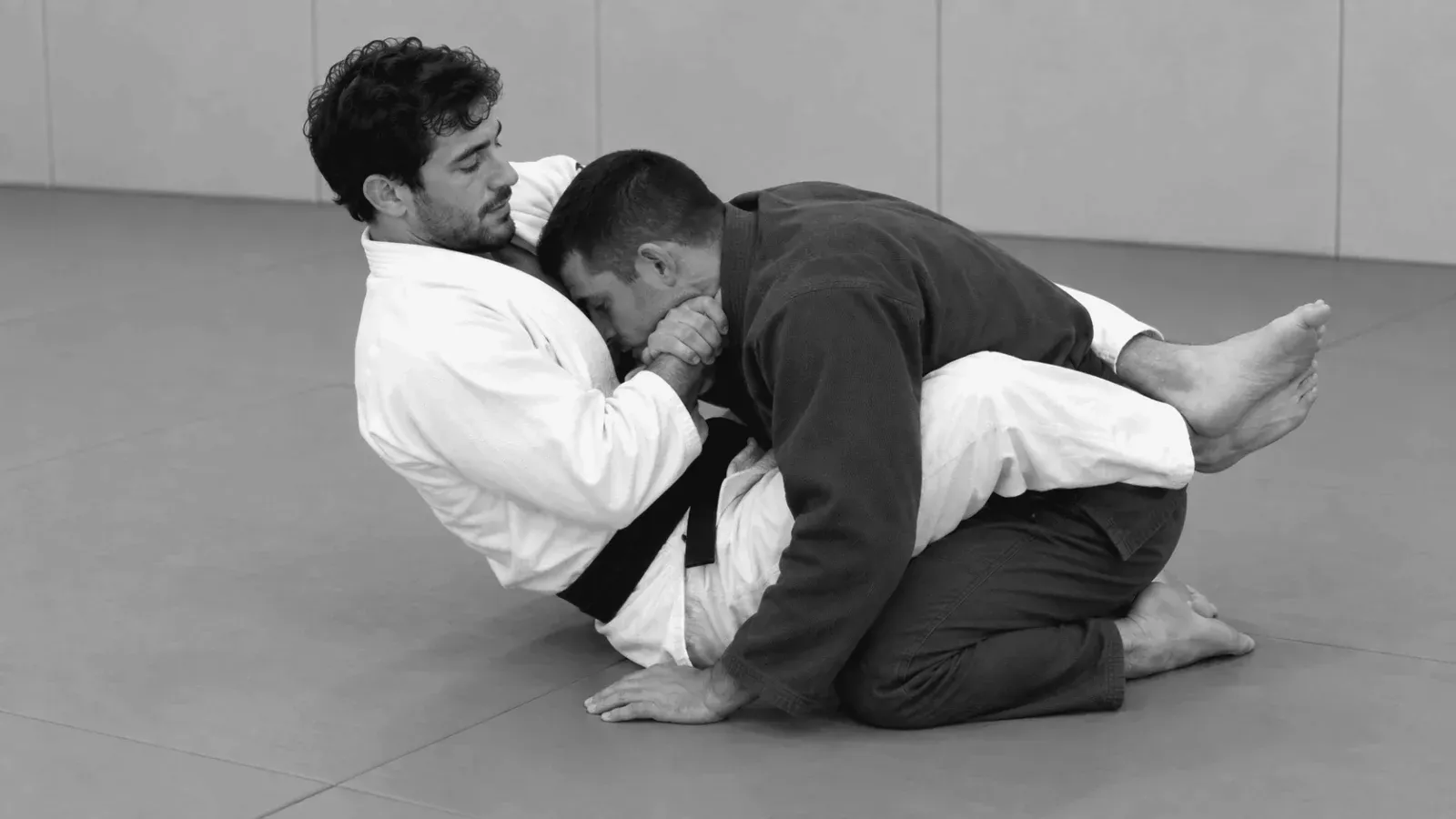 Gi partners practicing controlled guillotine grips from guard.