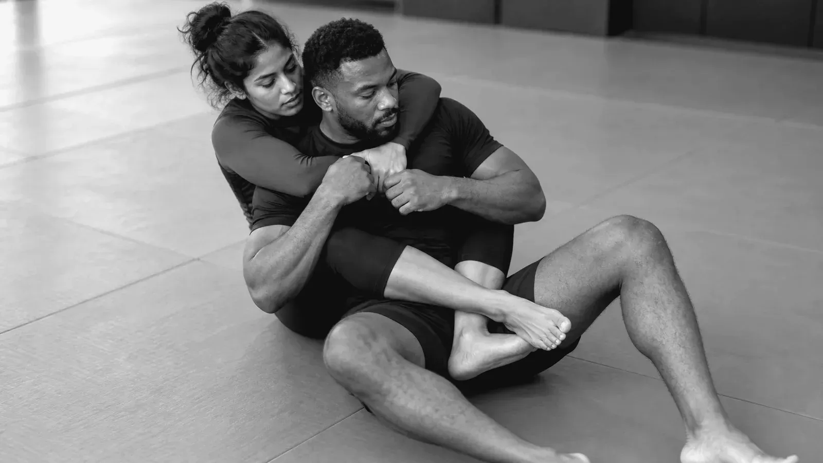 No-gi partners practicing seatbelt and leg control from the back.