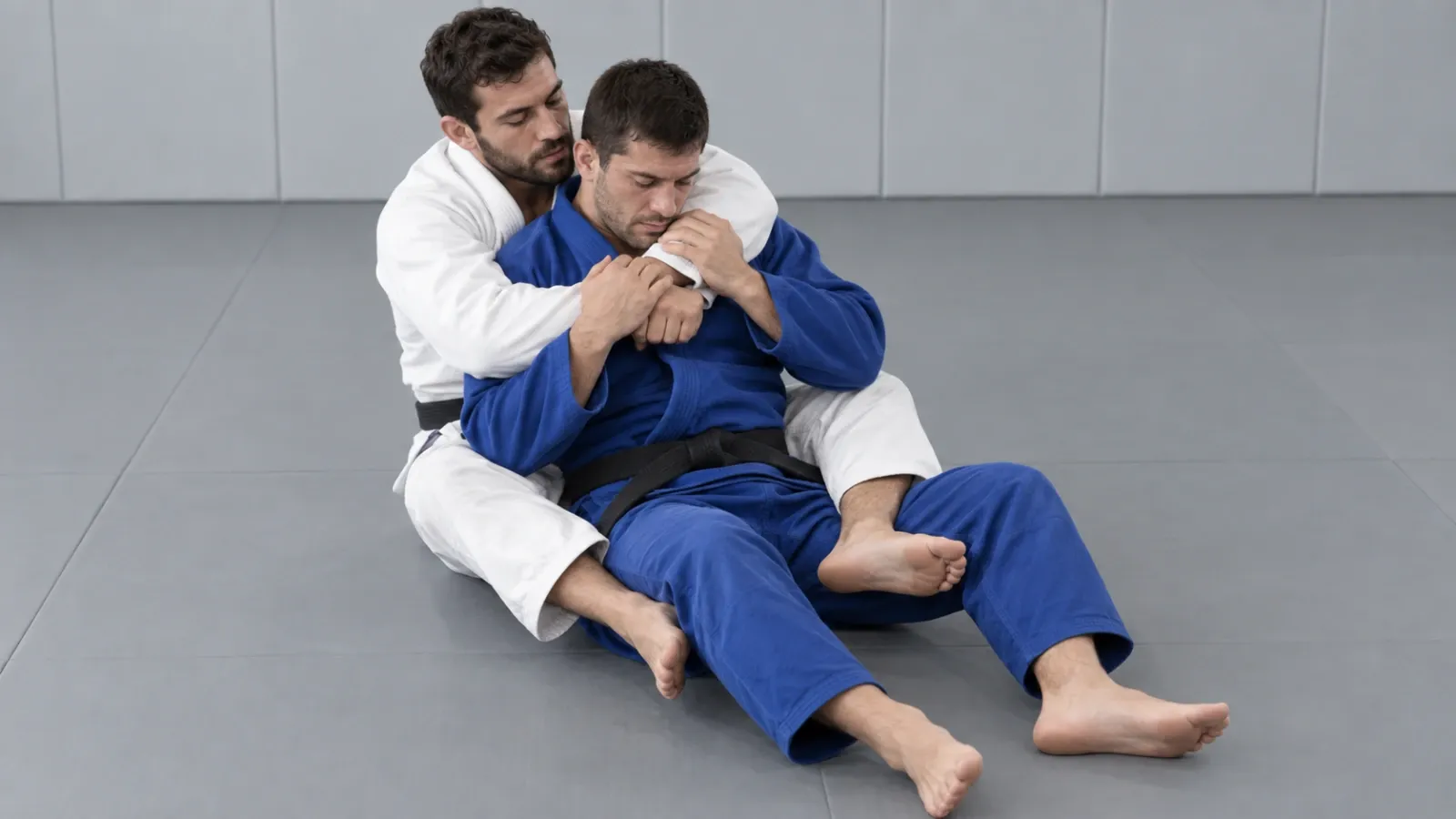 Back control with a seatbelt grip and the chest against the opponent’s spine, before the choke begins.